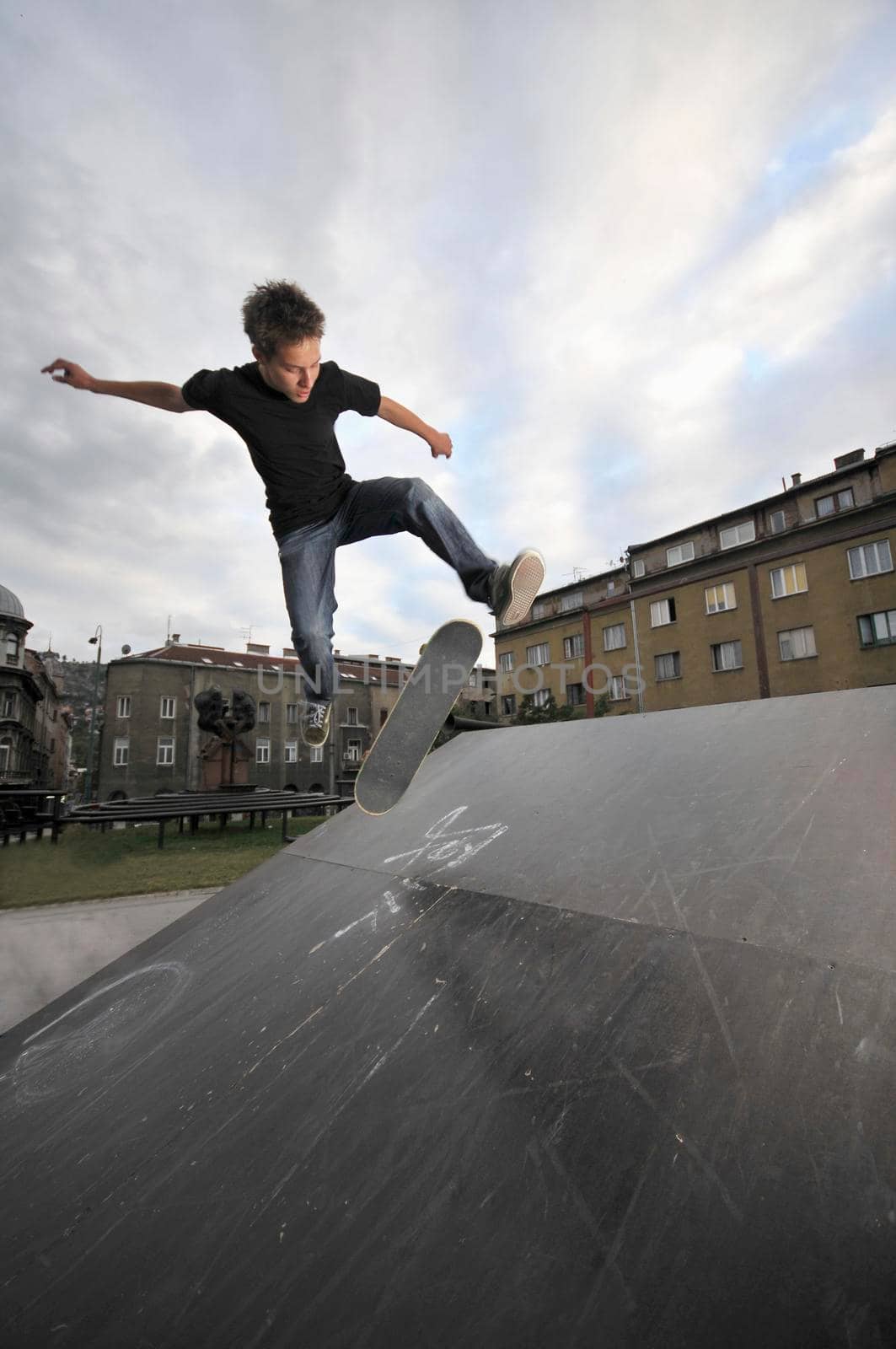 Boy practicing skate in a skate park by dotshock