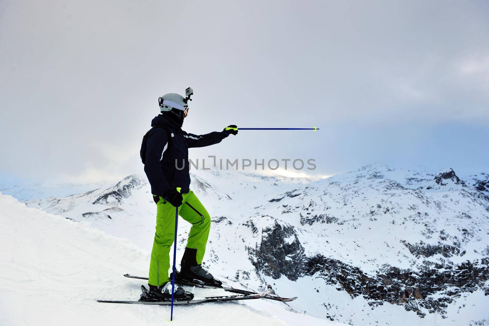 skier skiing downhill on fresh powder snow  with sun and mountains in background