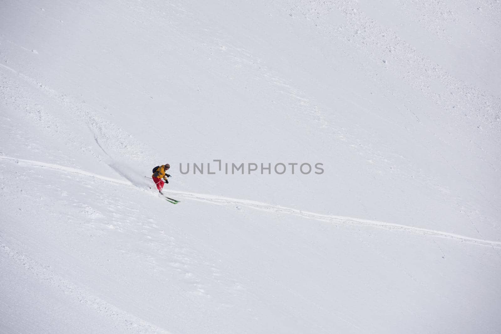 freeride skier skiing in deep powder snow by dotshock