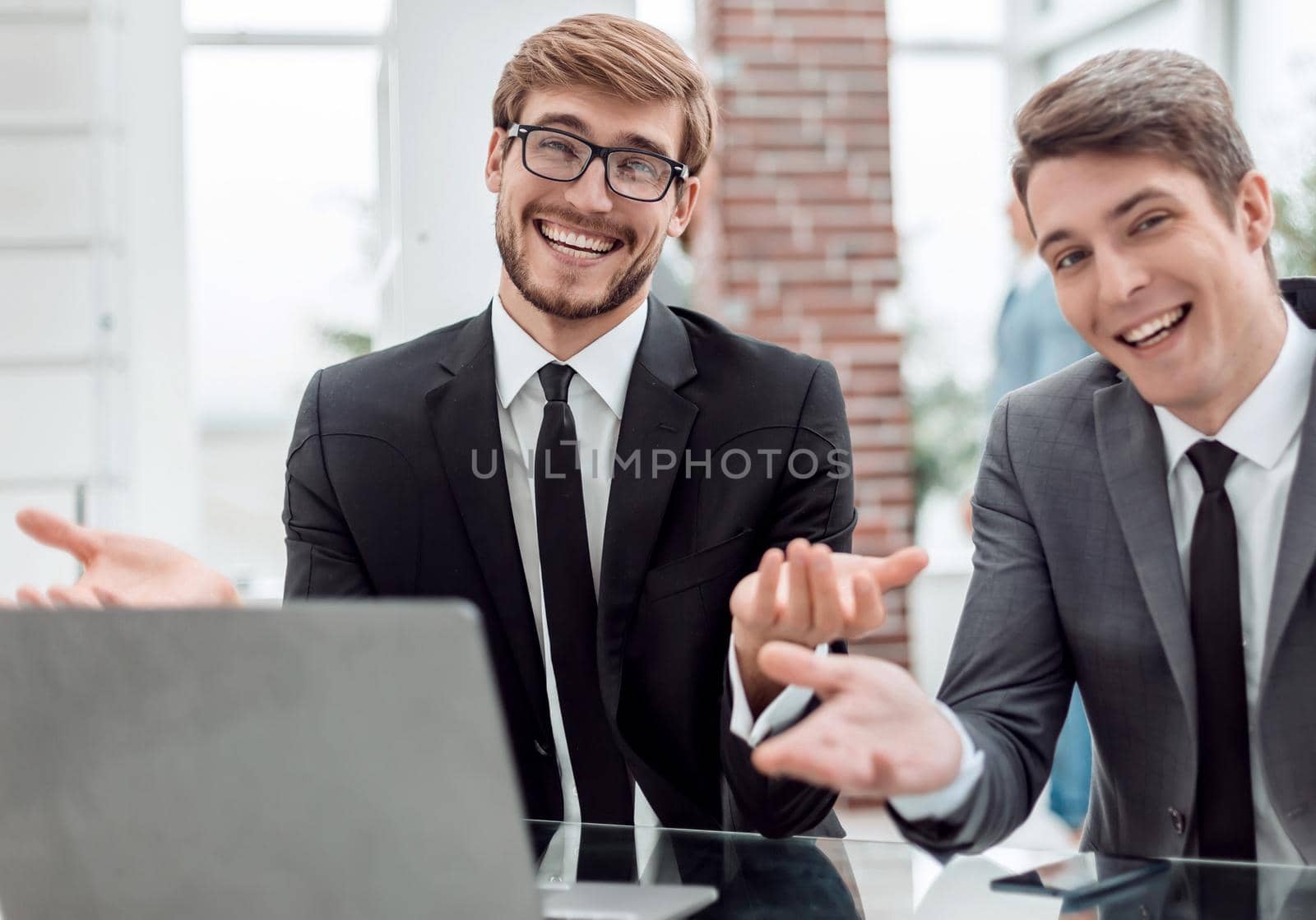 close up. two friendly businessmen sitting at the office Desk. business concept