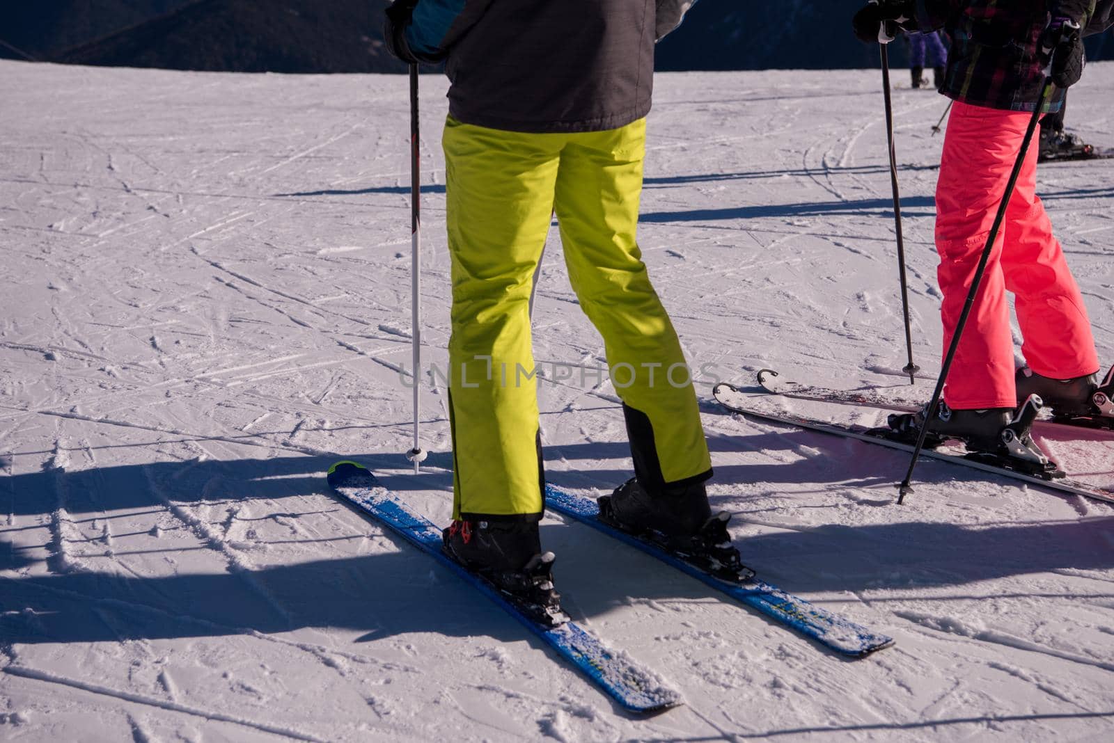 group of happy people having fun on snow during winter season at mountain with blue sky and fresh air in beautiful ski resort