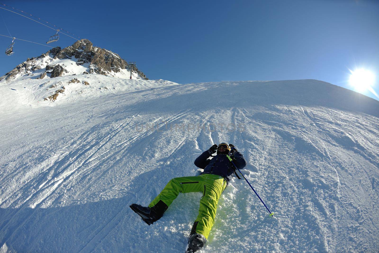 skier skiing downhill on fresh powder snow  with sun and mountains in background