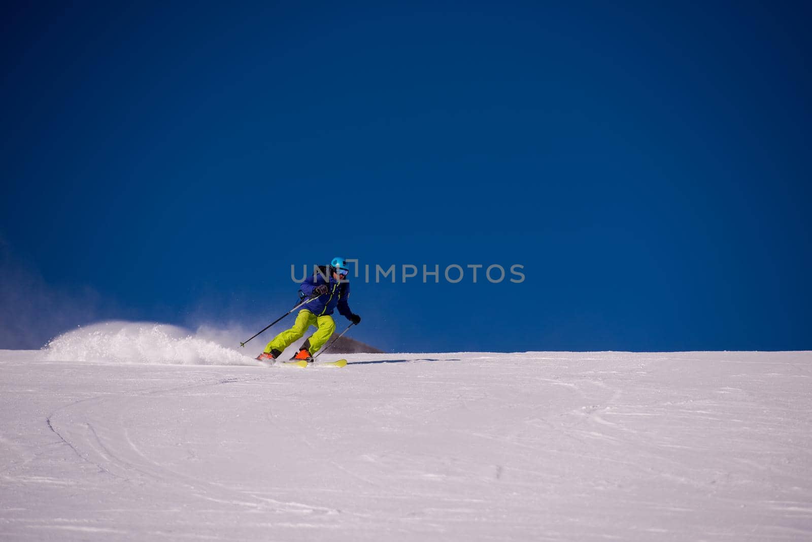 young athlete freestyle Skier having fun while running downhill in beautiful Alpine landscape on sunny day during winter season