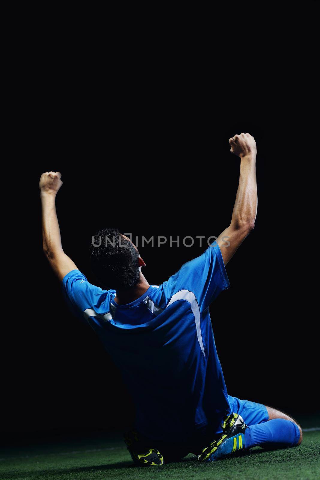 soccer player doing kick with ball on football stadium  field  isolated on black background