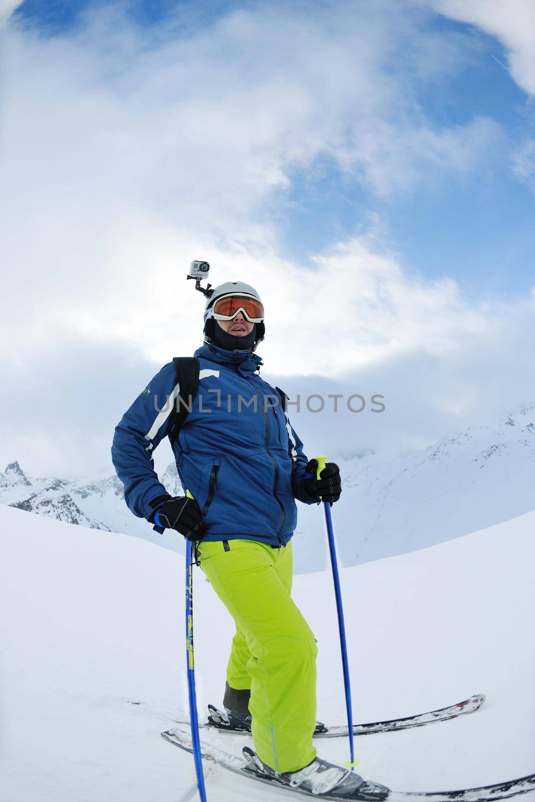 skier skiing downhill on fresh powder snow  with sun and mountains in background