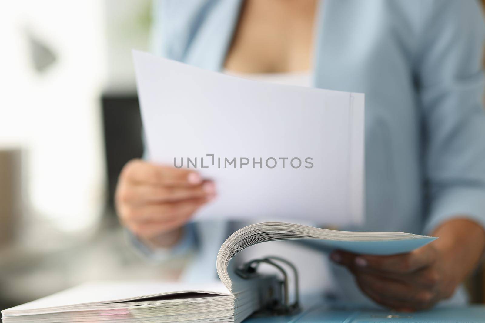 Business woman in suit looking documents from folder closeup by kuprevich