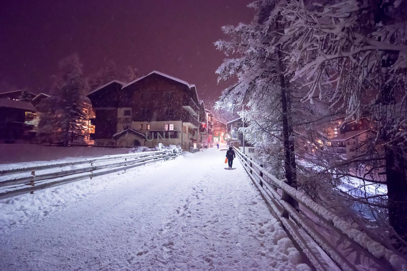 a view on snowy streets of the Alpine mountain village in the cold winter night