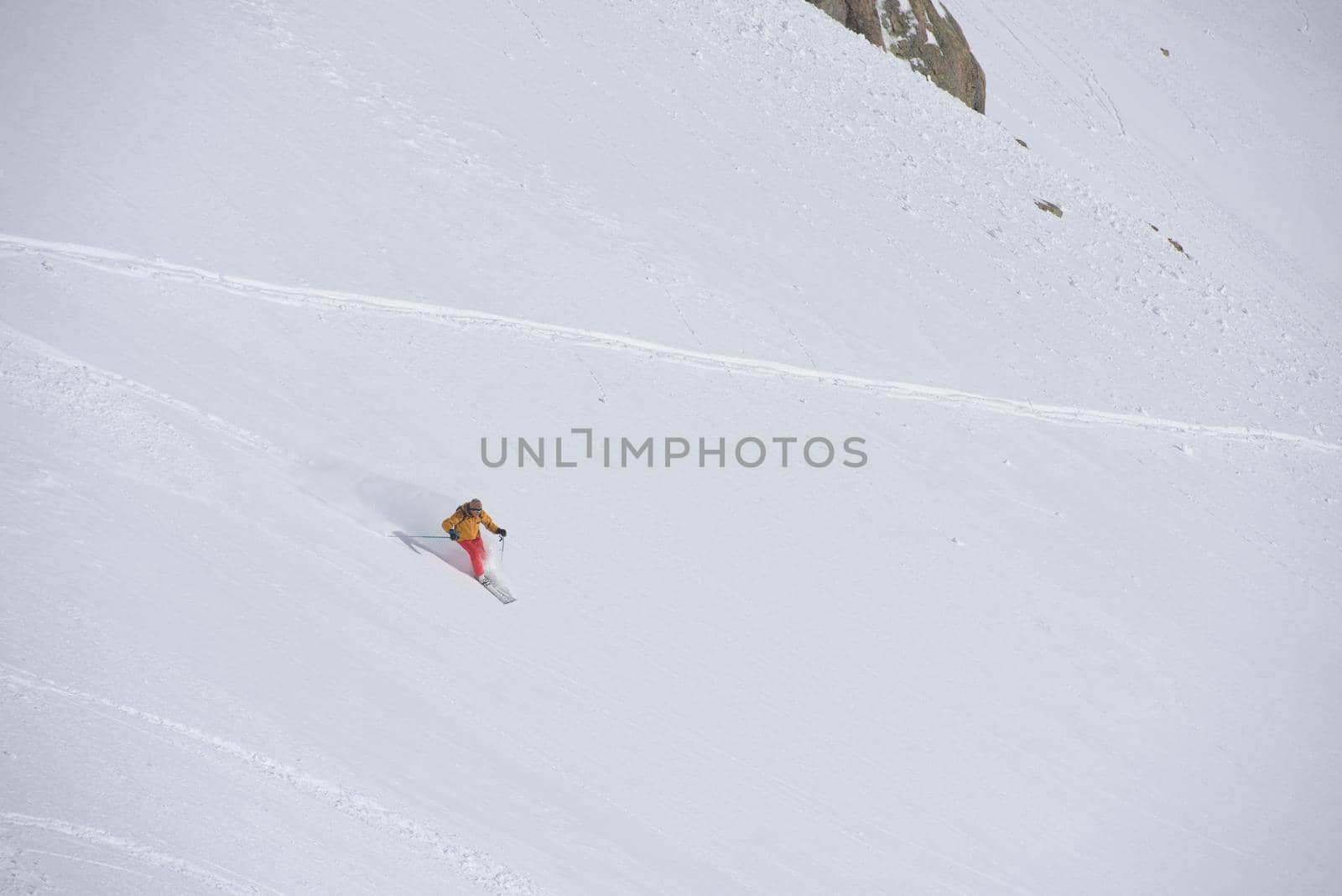 freeride skier skiing in deep powder snow by dotshock