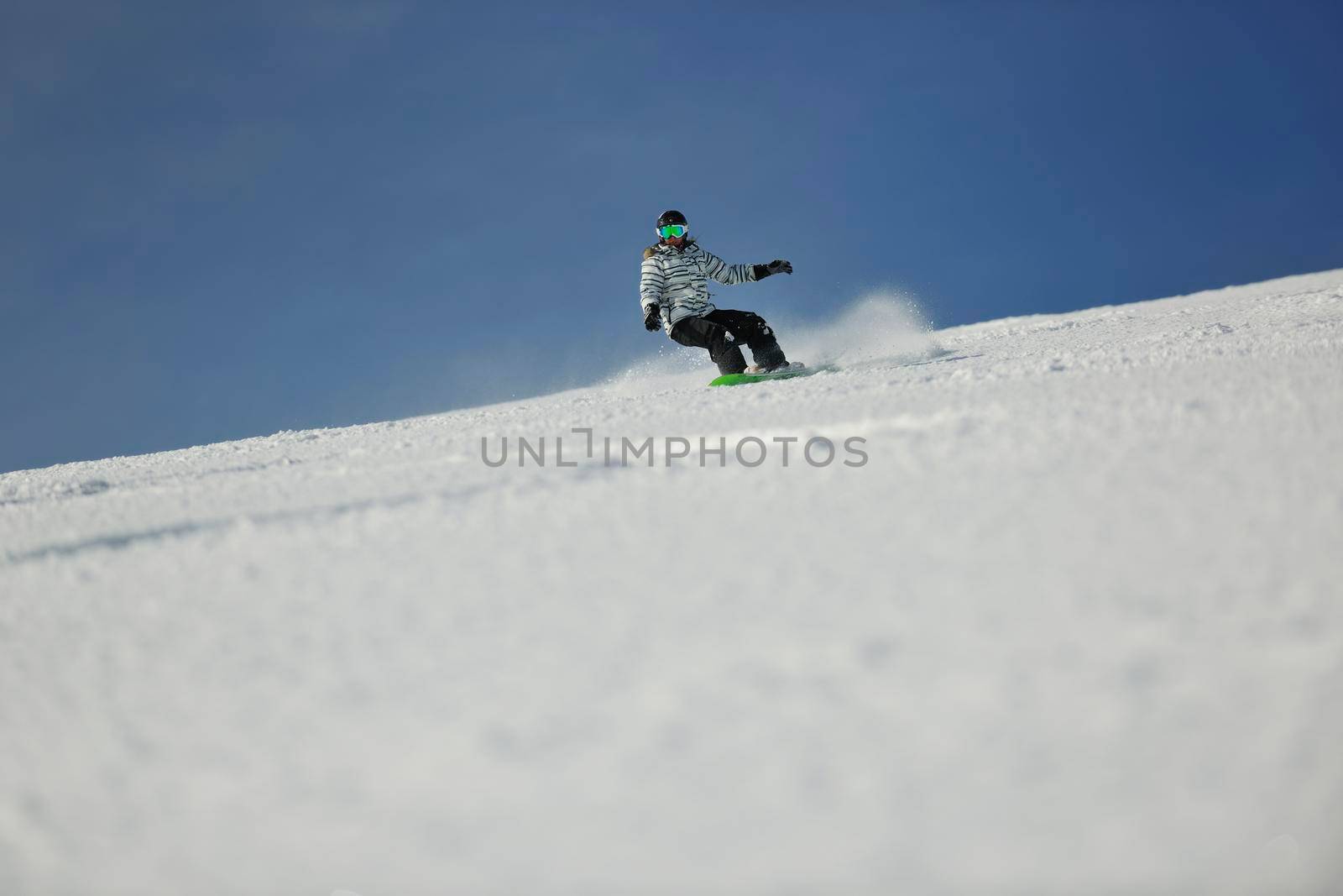 snowboard woman racing downhill slope and freeride on powder snow at winter season and sunny day