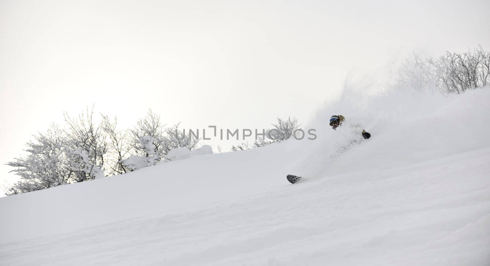 freestyle snowboarder jump and ride free style  at sunny winter day on mountain