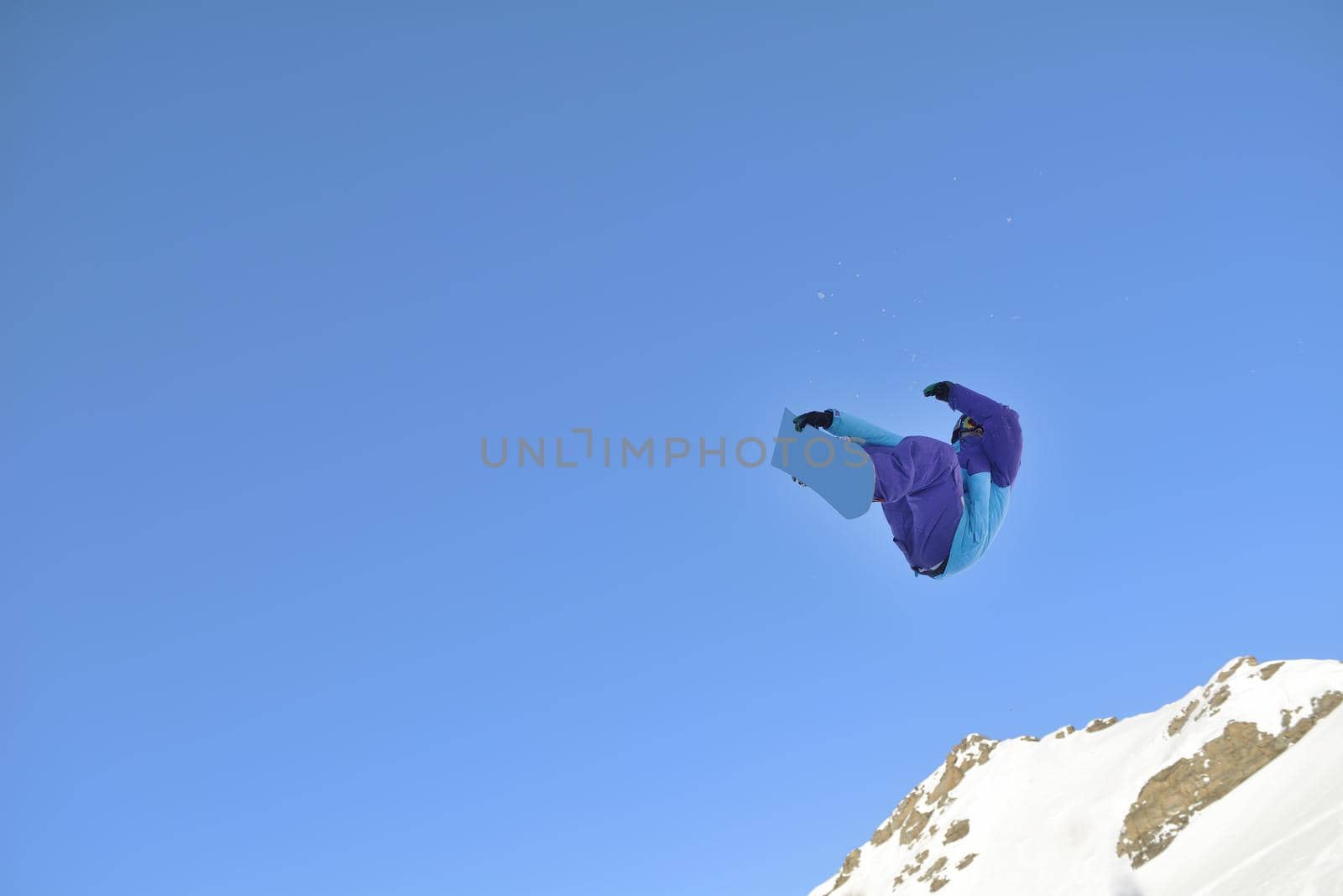 jumping freestyle skier at mountain with fresh snow fresh sunny winter day