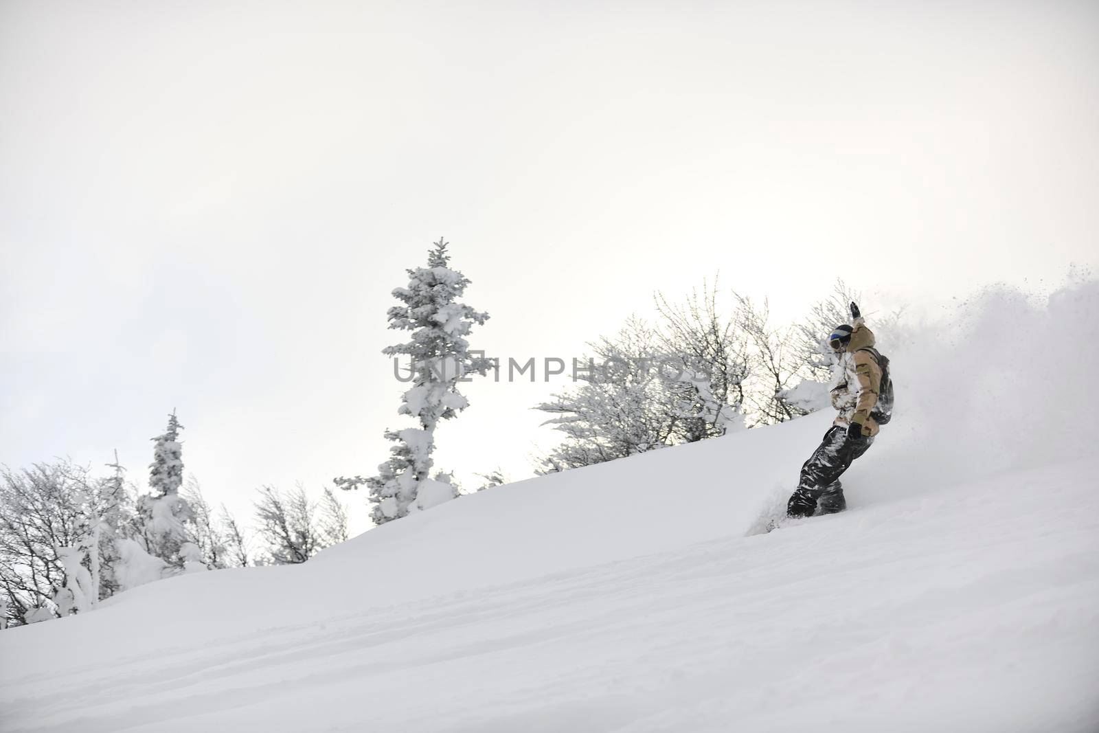 freestyle snowboarder jump and ride free style  at sunny winter day on mountain