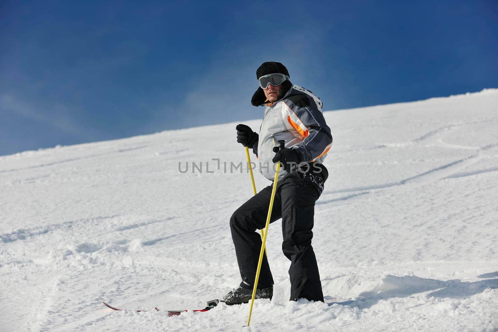 skier free ride downhill at winter season on beautiful sunny day 