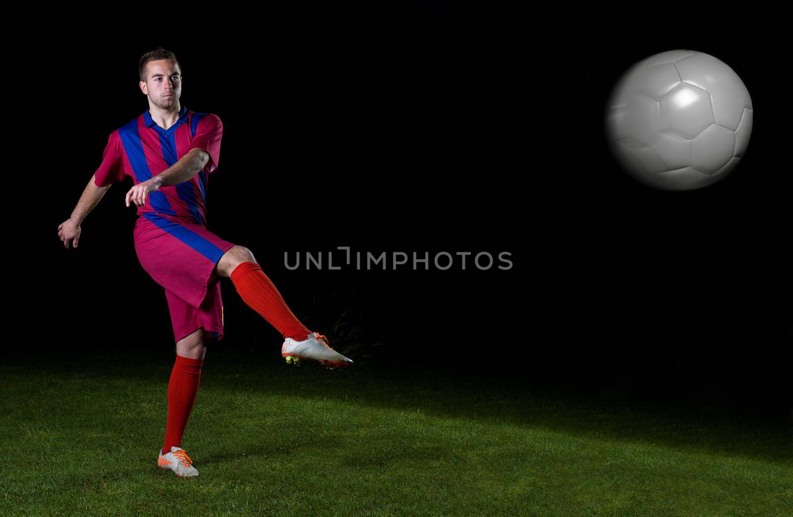 soccer player doing kick with ball on football stadium field