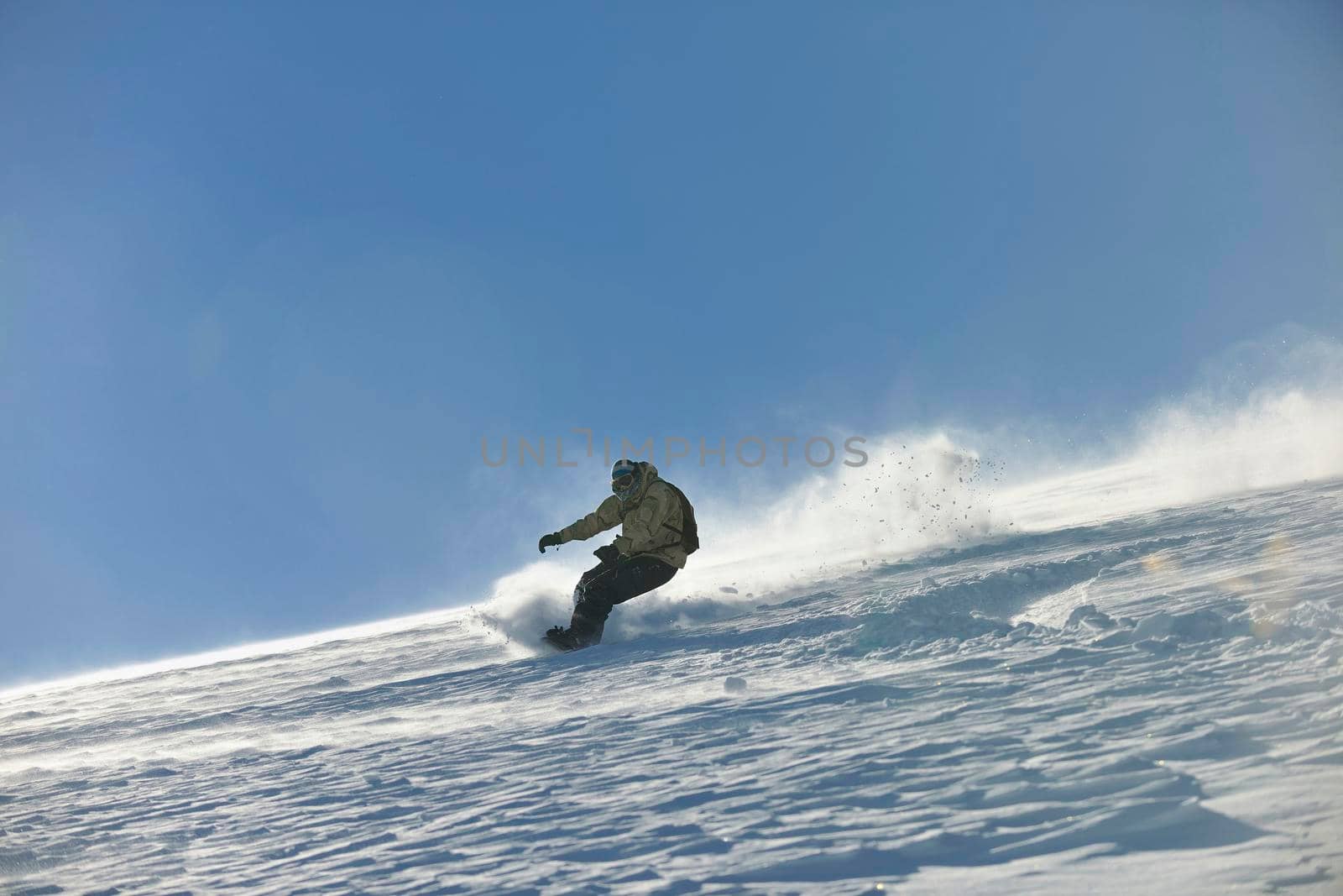 freestyle snowboarder jump and ride free style  at sunny winter day on mountain