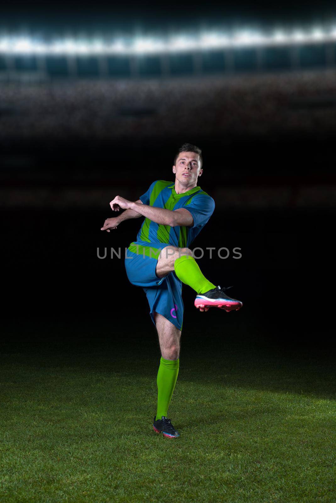 soccer player doing kick with ball on football stadium field