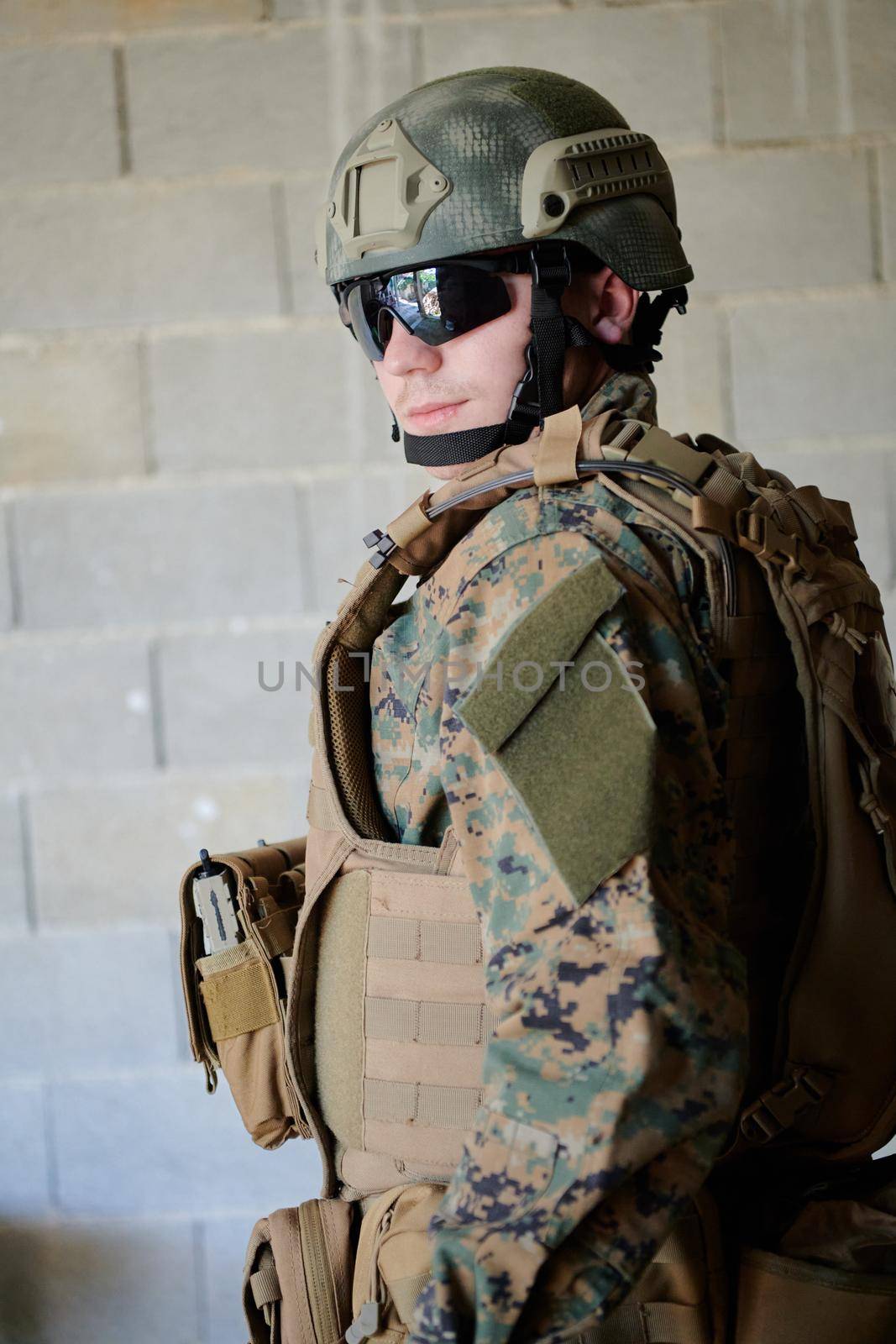 soldier portrait with  protective army tactical gear  against old brick wall