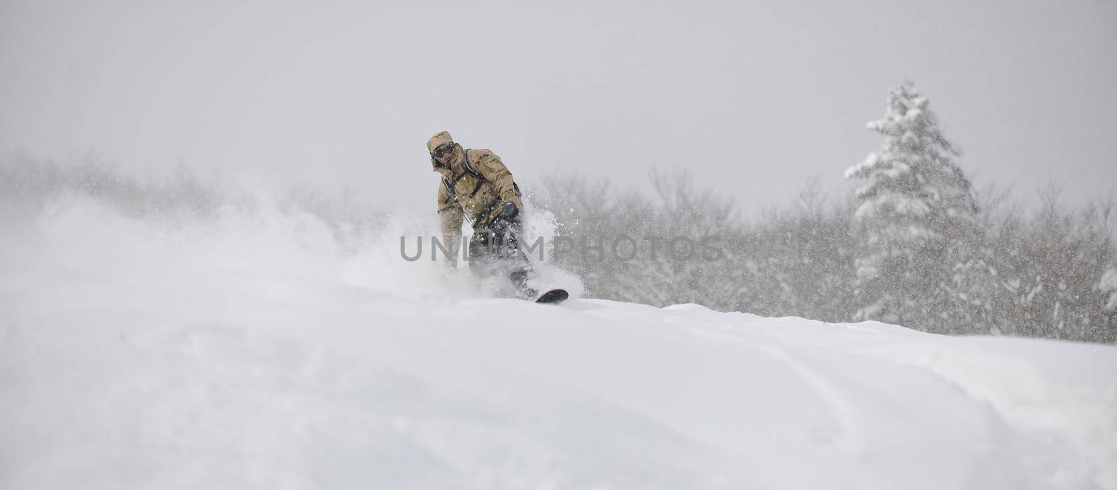 freestyle snowboarder jump and ride free style  at sunny winter day on mountain