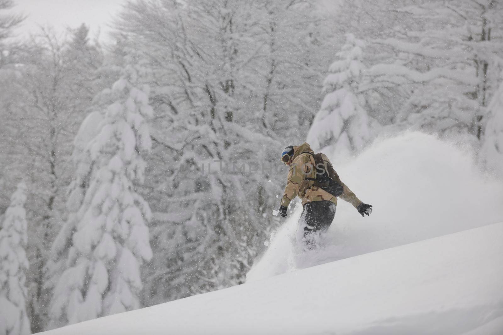 freestyle snowboarder jump and ride free style  at sunny winter day on mountain