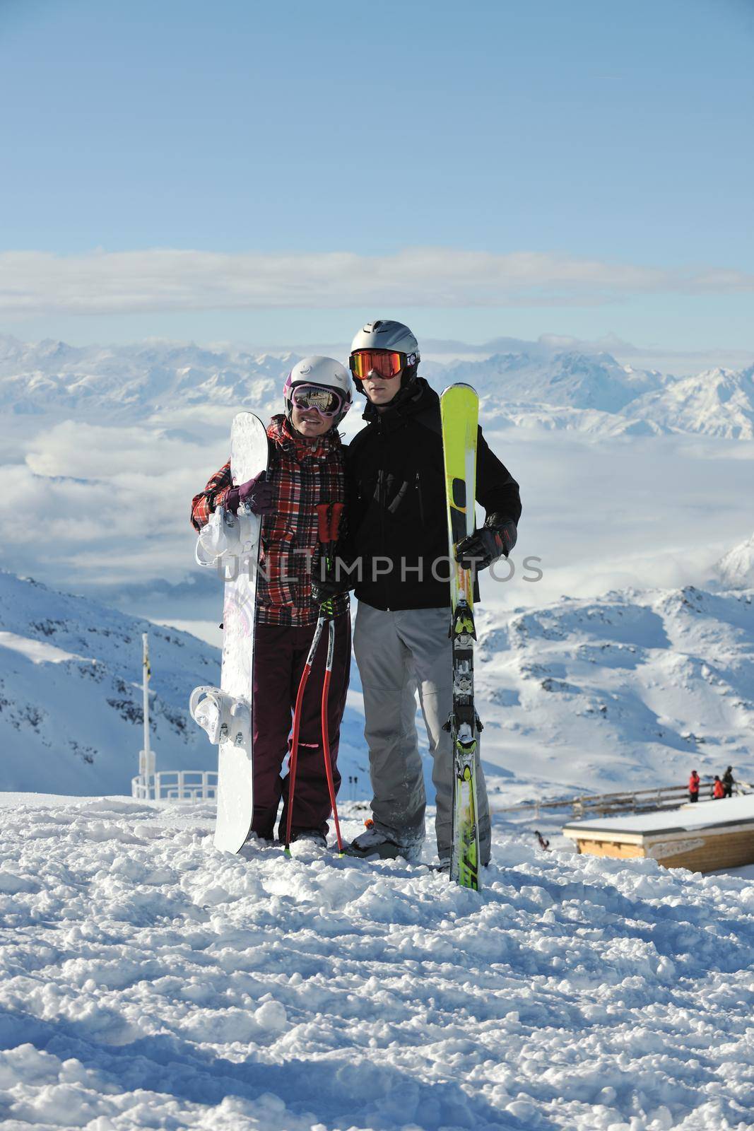 happy people group have fun on snow at winter season on mountain with blue sky and fresh air