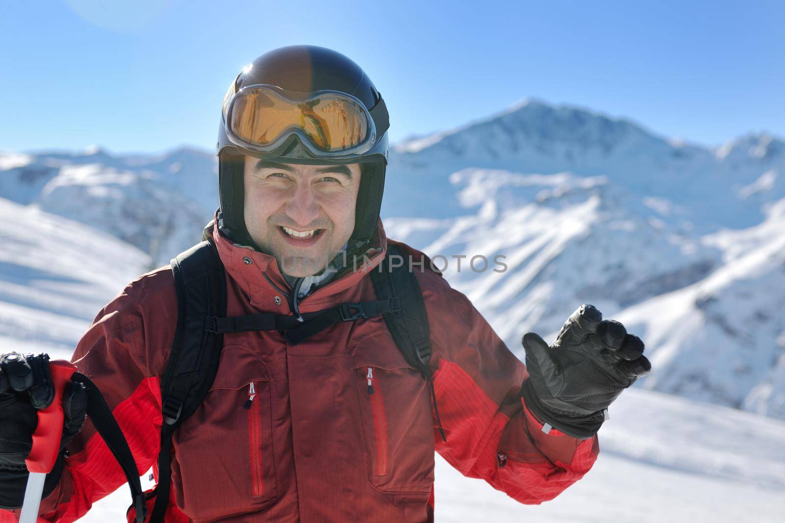 skier skiing downhill on fresh powder snow  with sun and mountains in background