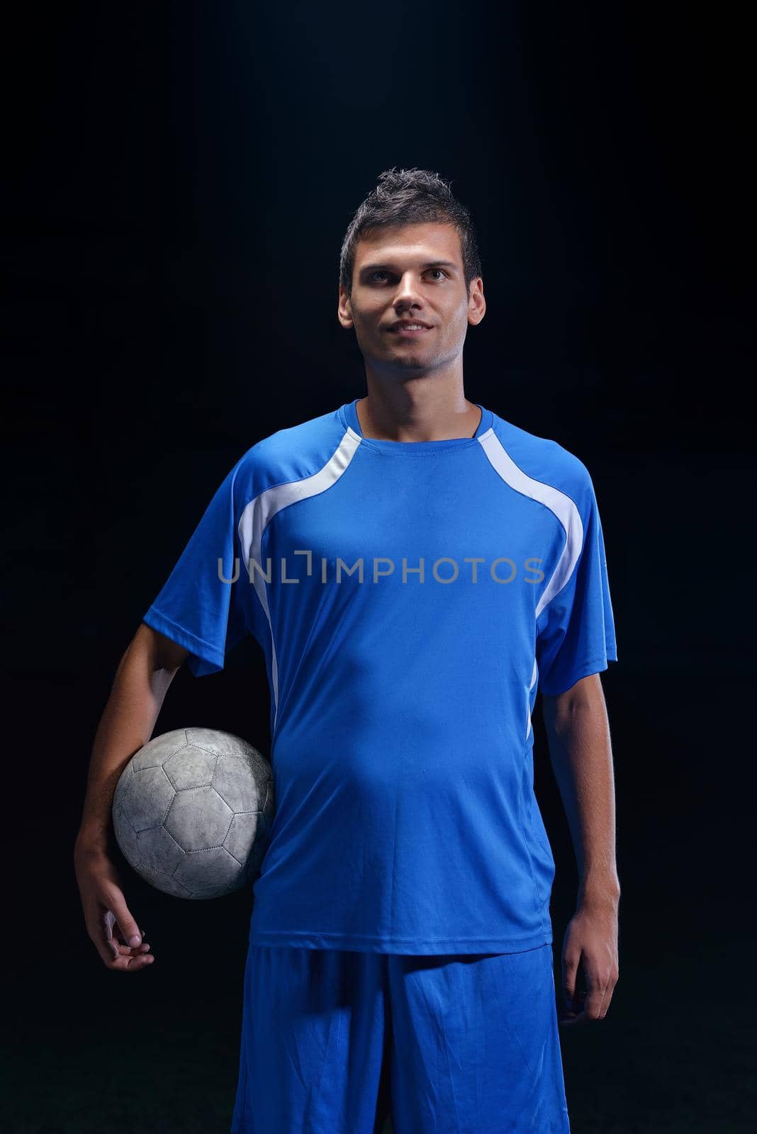 soccer player doing kick with ball on football stadium  field  isolated on black background