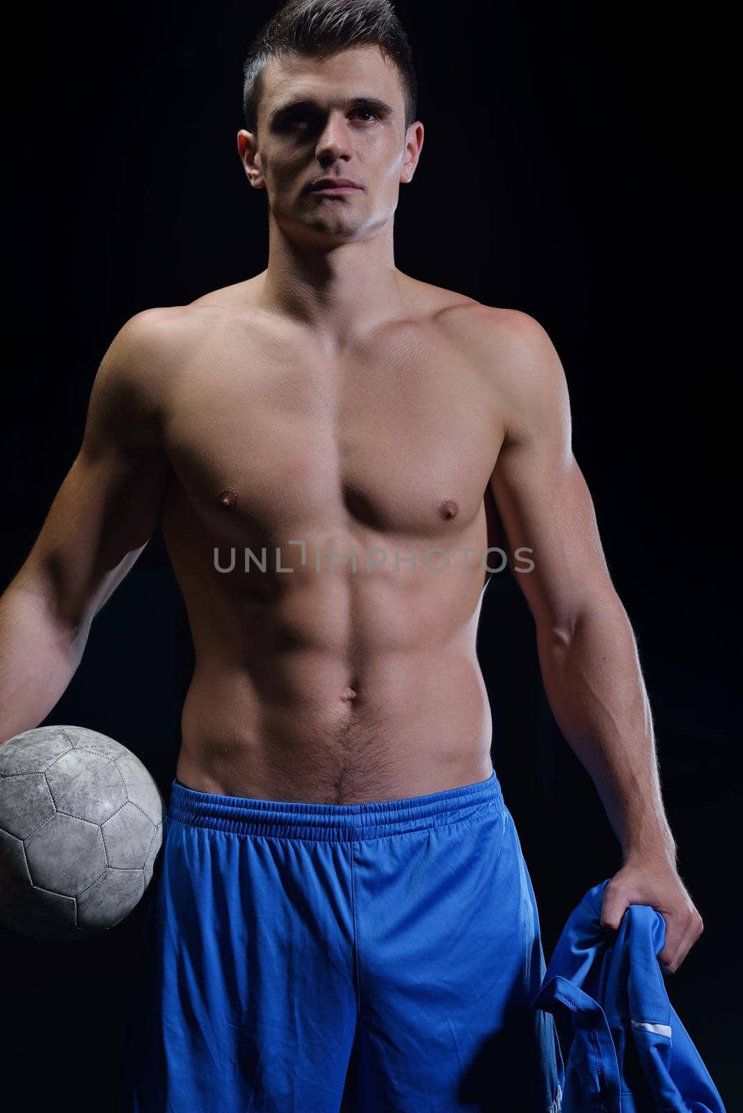 soccer player doing kick with ball on football stadium  field  isolated on black background