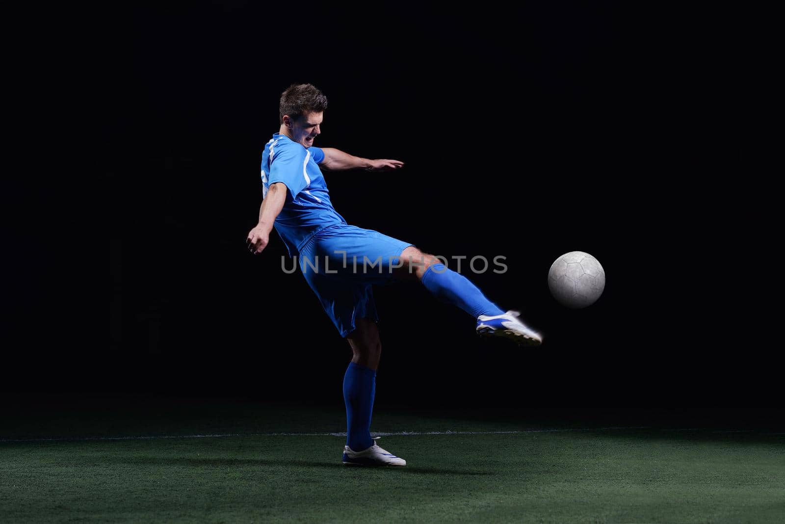 soccer player doing kick with ball on football stadium  field  isolated on black background