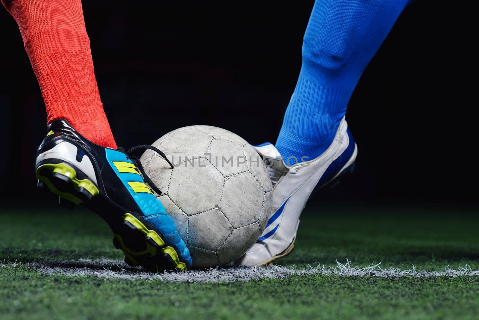 soccer player doing kick with ball on football stadium  field  isolated on black background