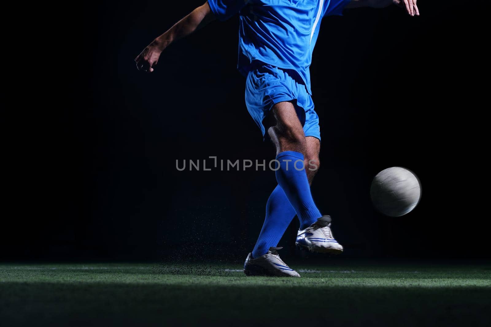 soccer player doing kick with ball on football stadium  field  isolated on black background