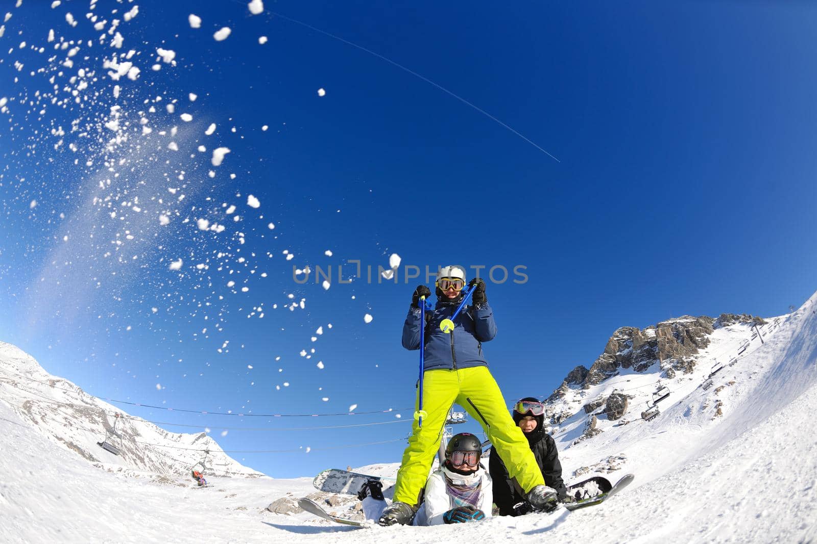 happy people group have fun on ski snow at winter season on mountain with blue sky and fresh air