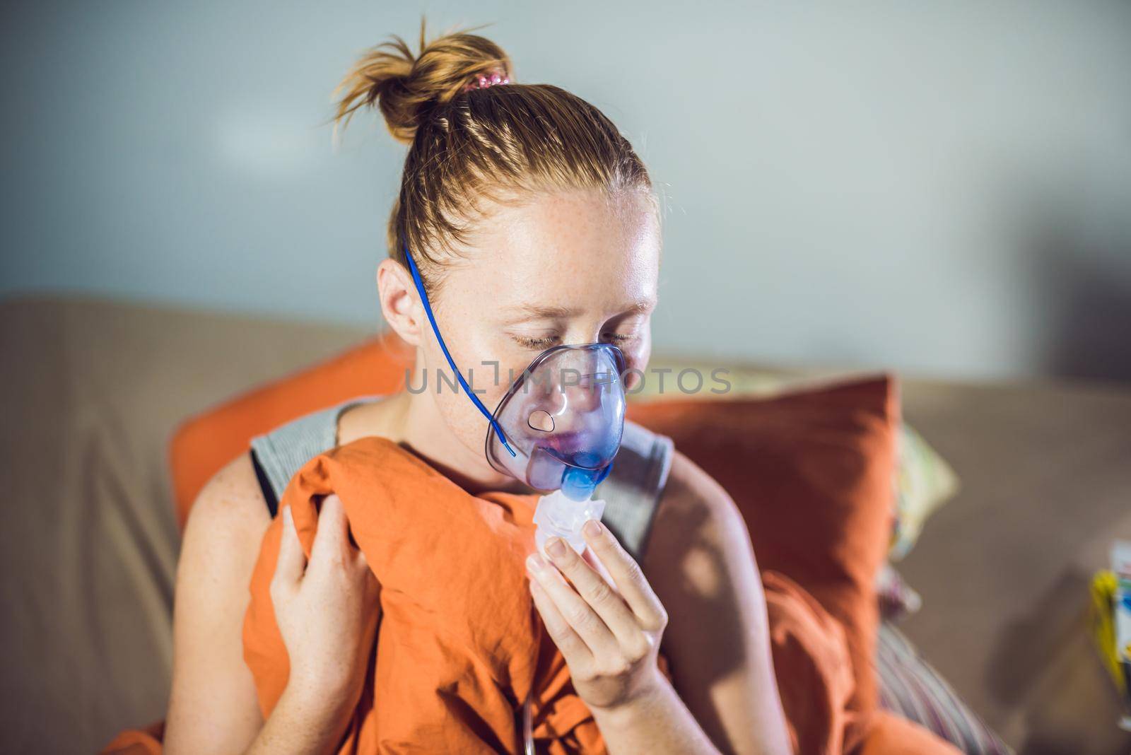 Woman with flu or cold symptoms making inhalation with nebulizer - medical inhalation therapy by galitskaya