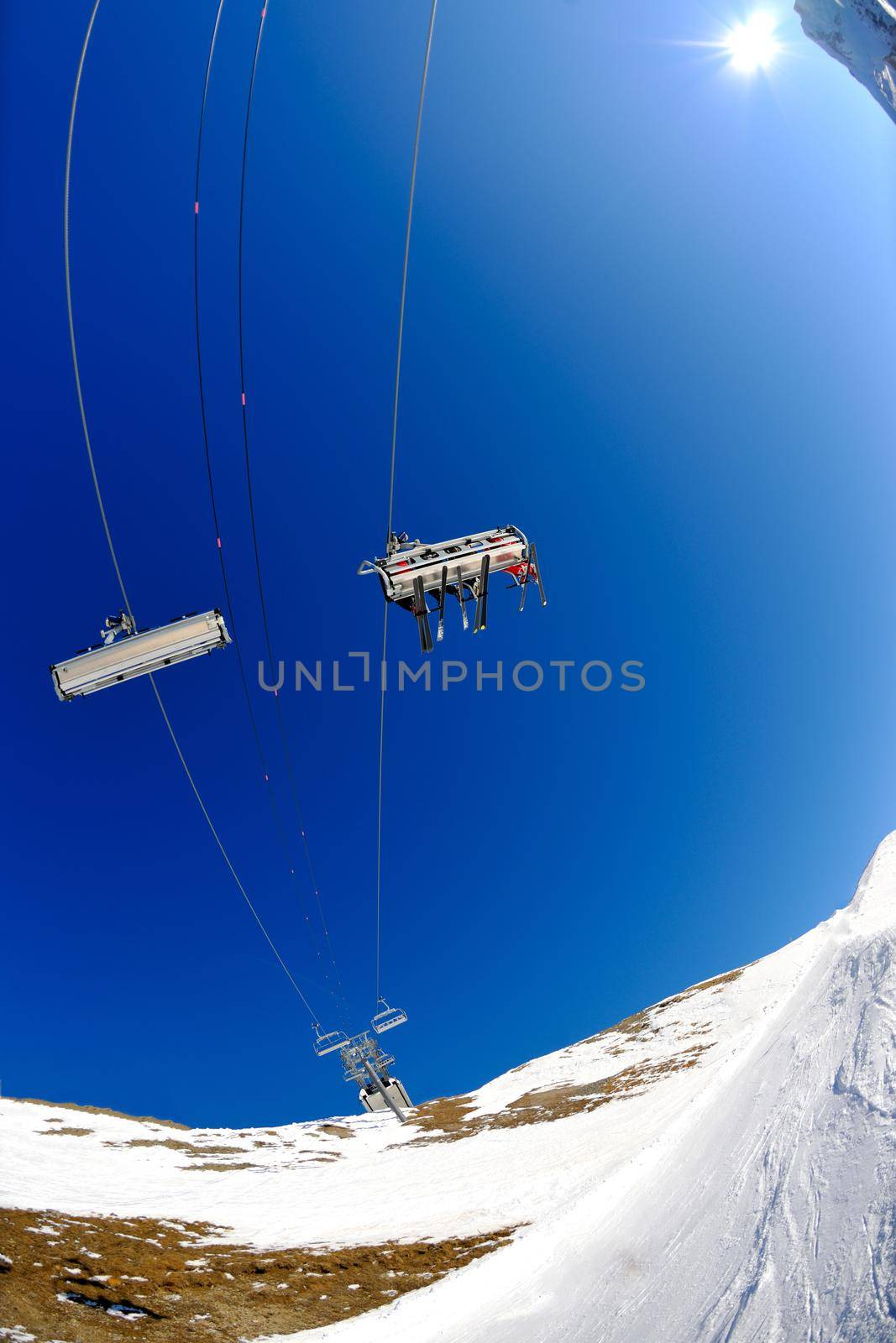 Ski lift - happy skiers use vertical transport  on ski vacation at sunny winter snow day