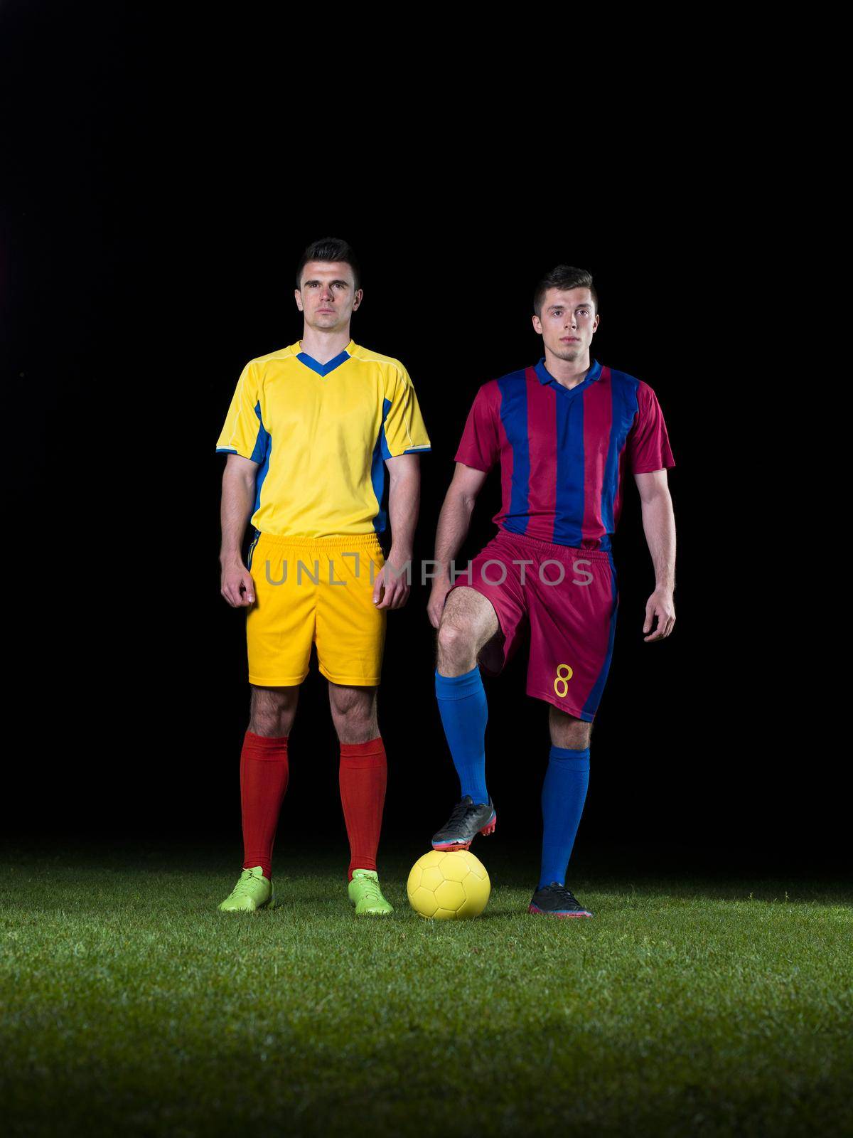 soccer player doing kick with ball on football stadium  field  isolated on black background