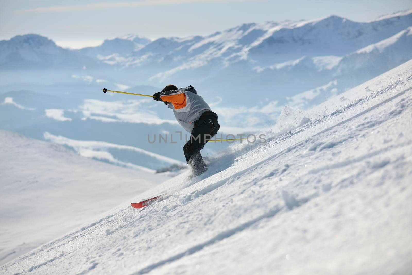 skier free ride downhill at winter season on beautiful sunny day 
