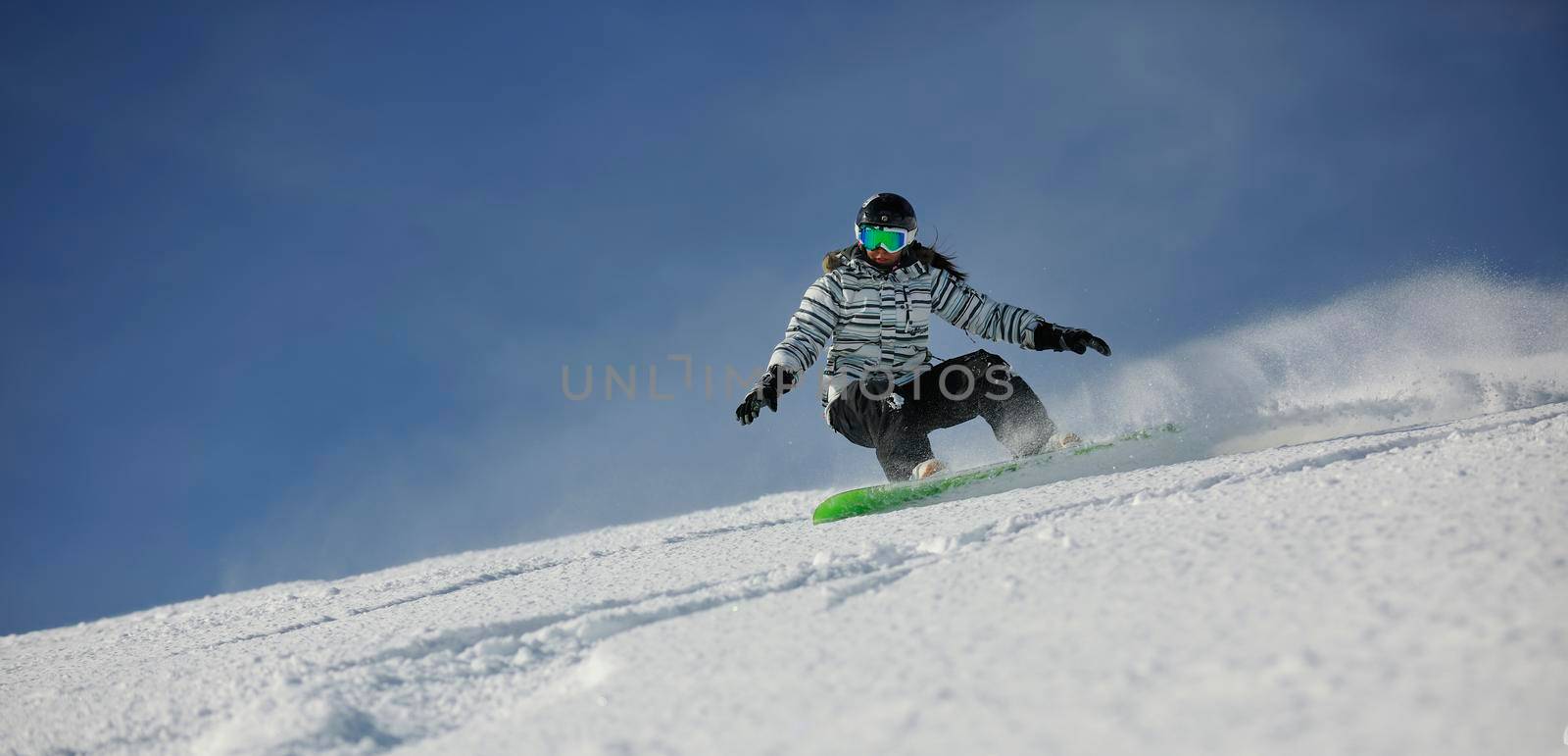 snowboard woman racing downhill slope and freeride on powder snow at winter season and sunny day