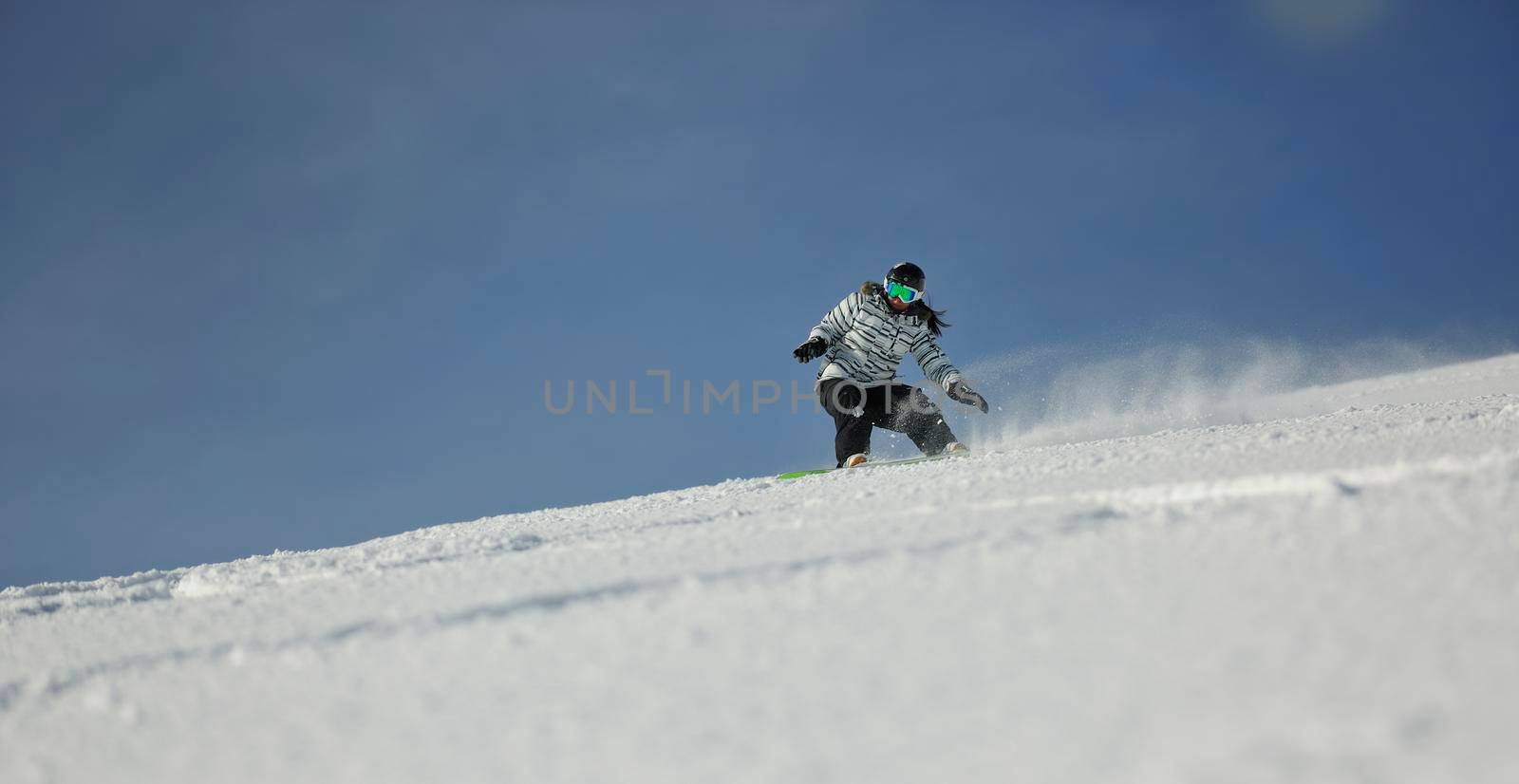 snowboard woman racing downhill slope and freeride on powder snow at winter season and sunny day