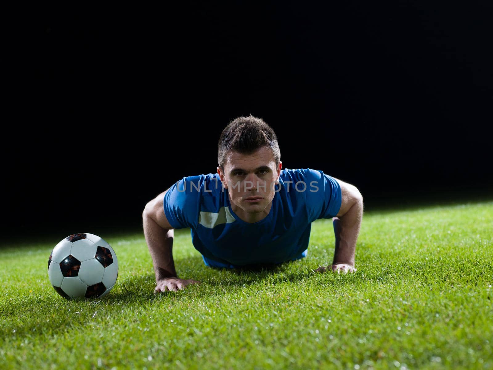 soccer player doing kick with ball on football stadium  field  isolated on black background