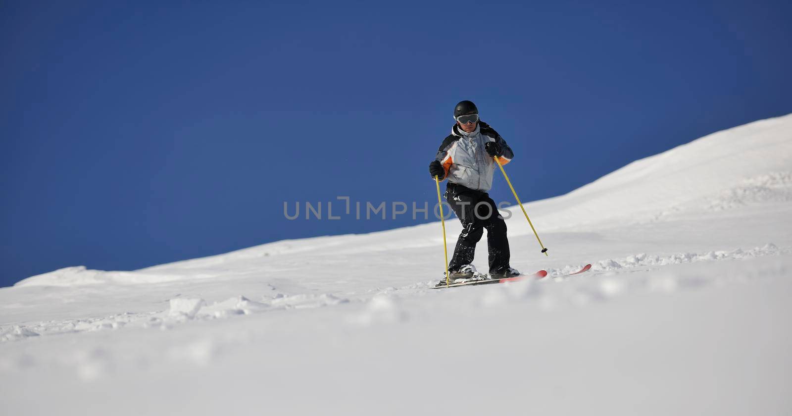 man ski free ride downhill at winter season on beautiful sunny day and powder snow