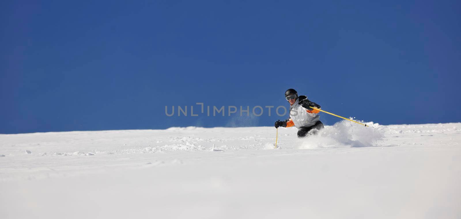 man ski free ride downhill at winter season on beautiful sunny day and powder snow