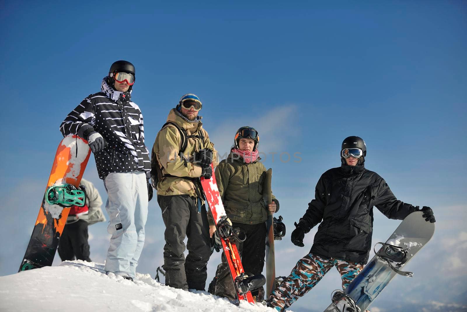 young snowboarders group have fun and relax at sunny winter day on winter season