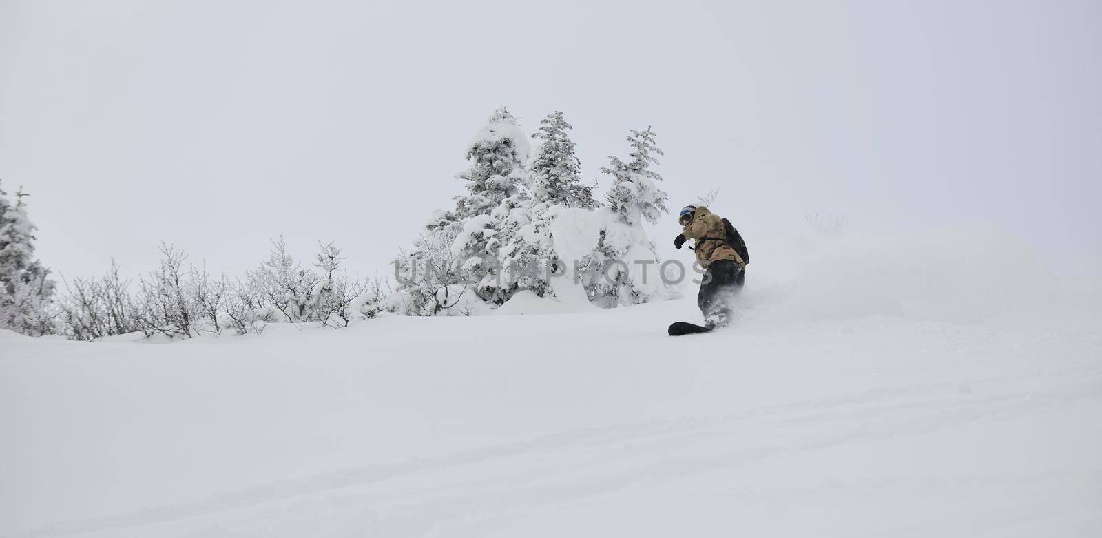 freestyle snowboarder jump and ride free style  at sunny winter day on mountain