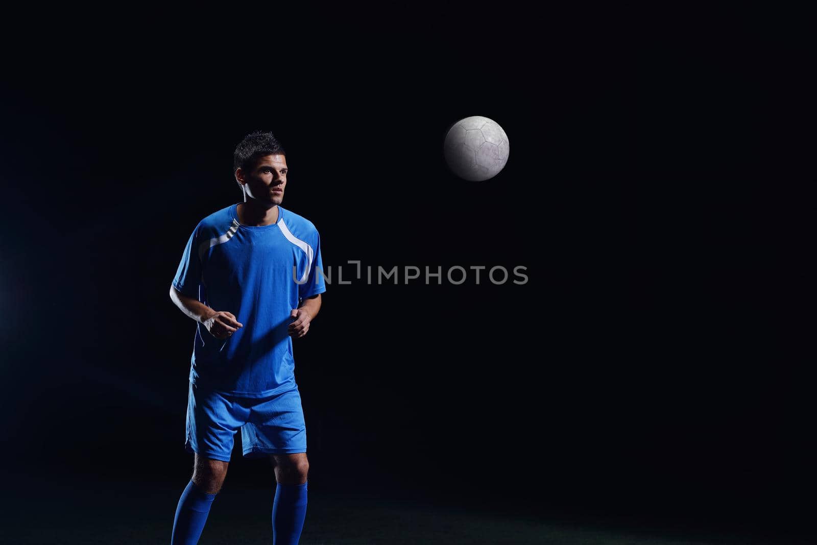 soccer player doing kick with ball on football stadium  field  isolated on black background