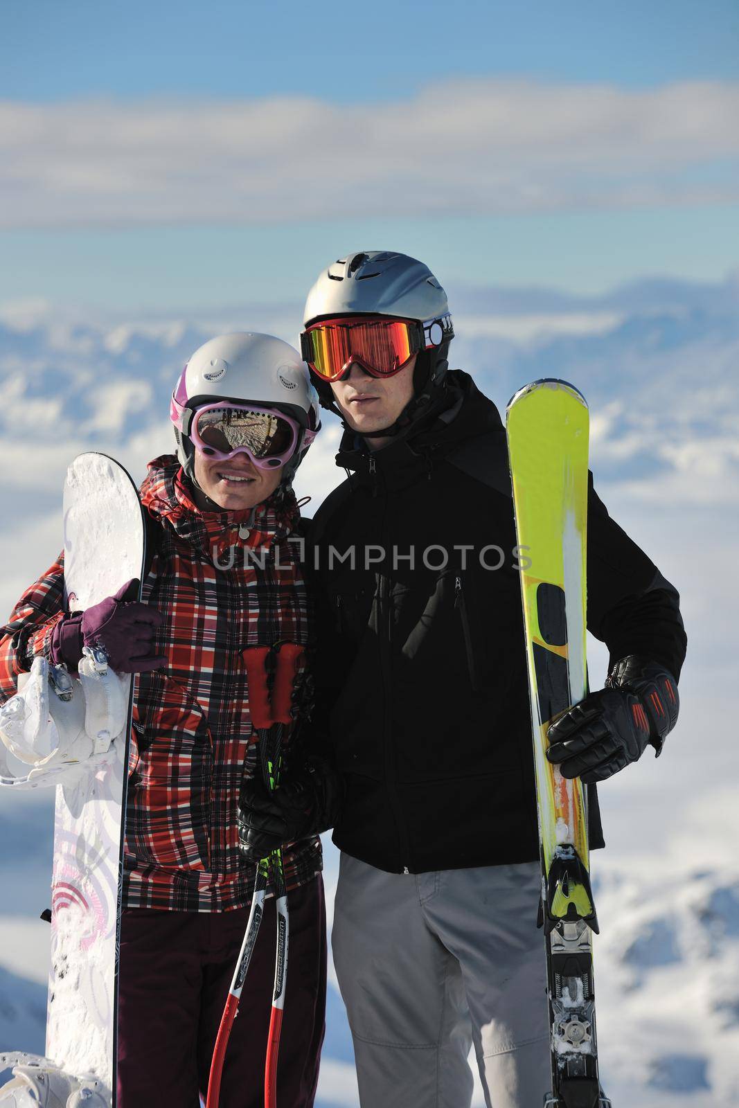 happy people group have fun on snow at winter season on mountain with blue sky and fresh air