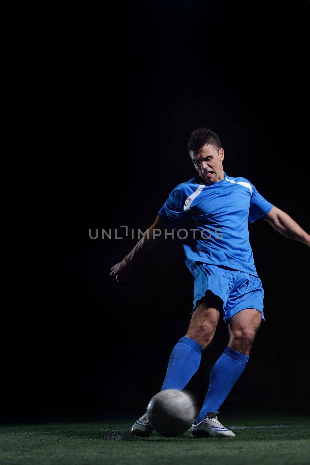 soccer player doing kick with ball on football stadium  field  isolated on black background