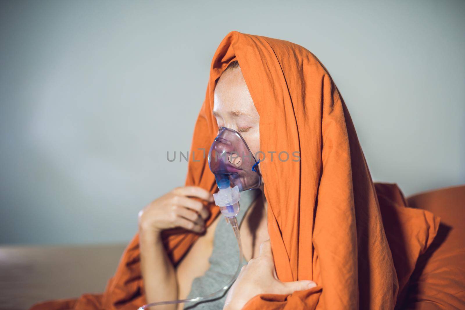 Woman with flu or cold symptoms making inhalation with nebulizer - medical inhalation therapy by galitskaya