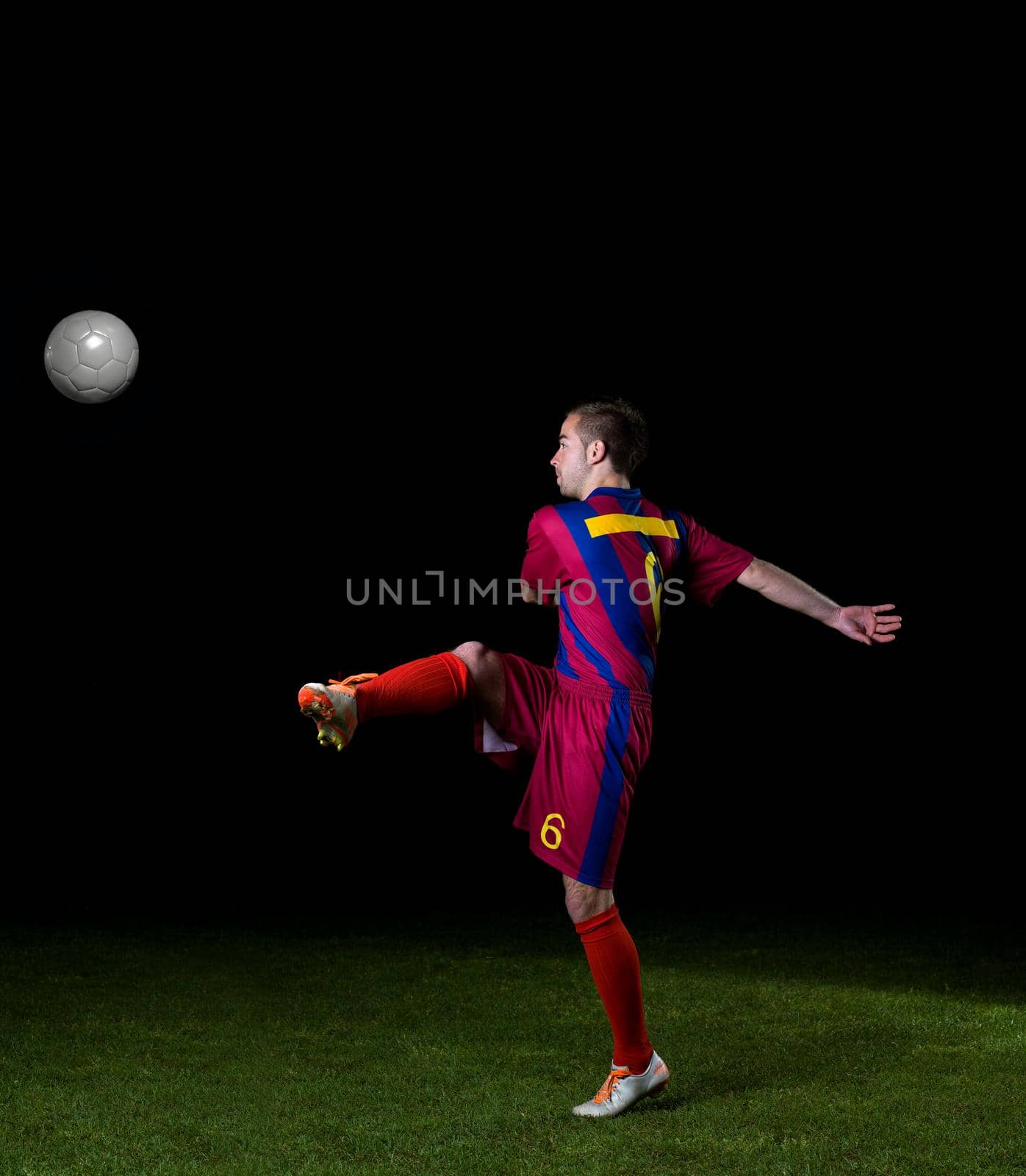 soccer player doing kick with ball on football stadium  field  isolated on black background