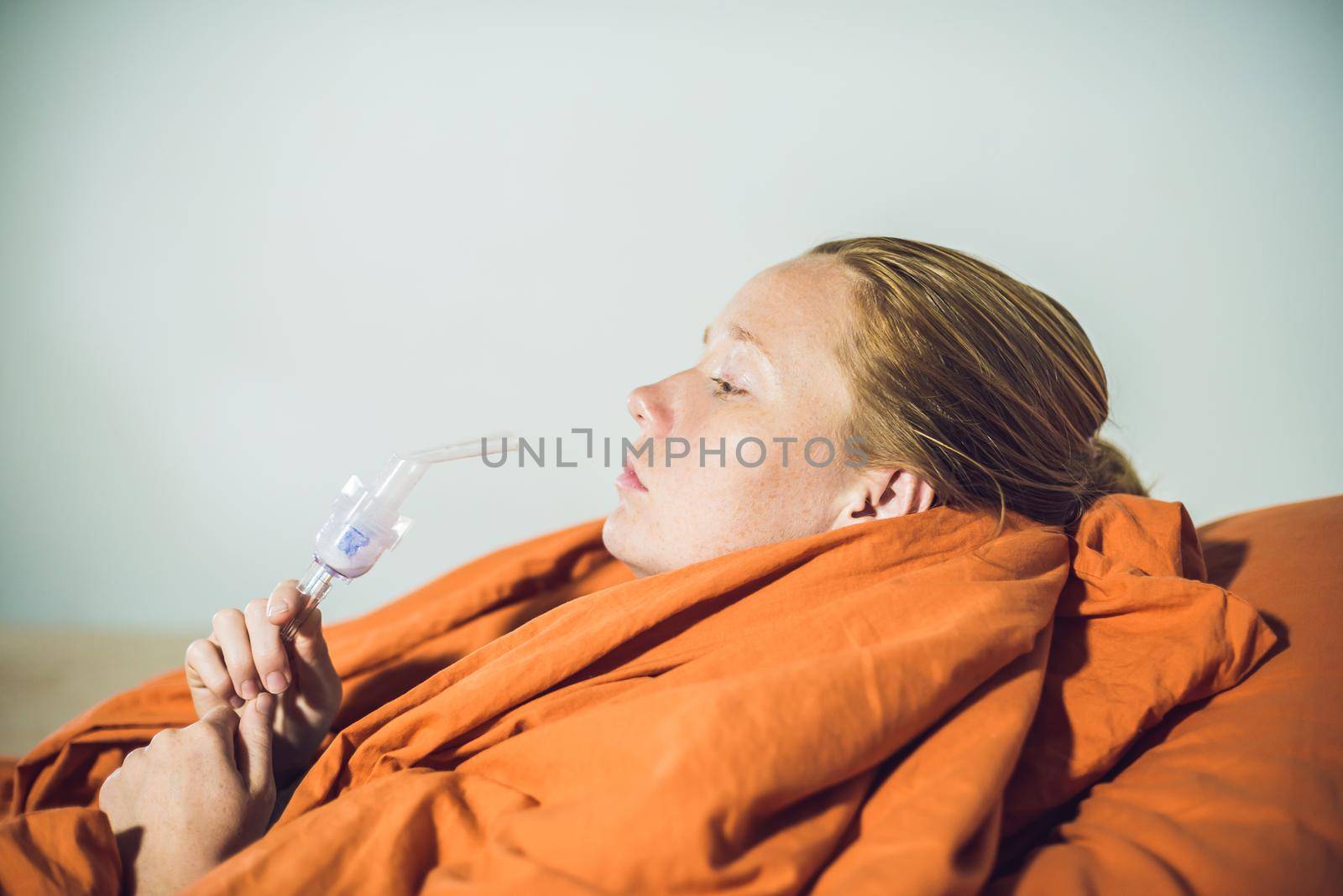 Woman with flu or cold symptoms making inhalation with nebulizer - medical inhalation therapy by galitskaya