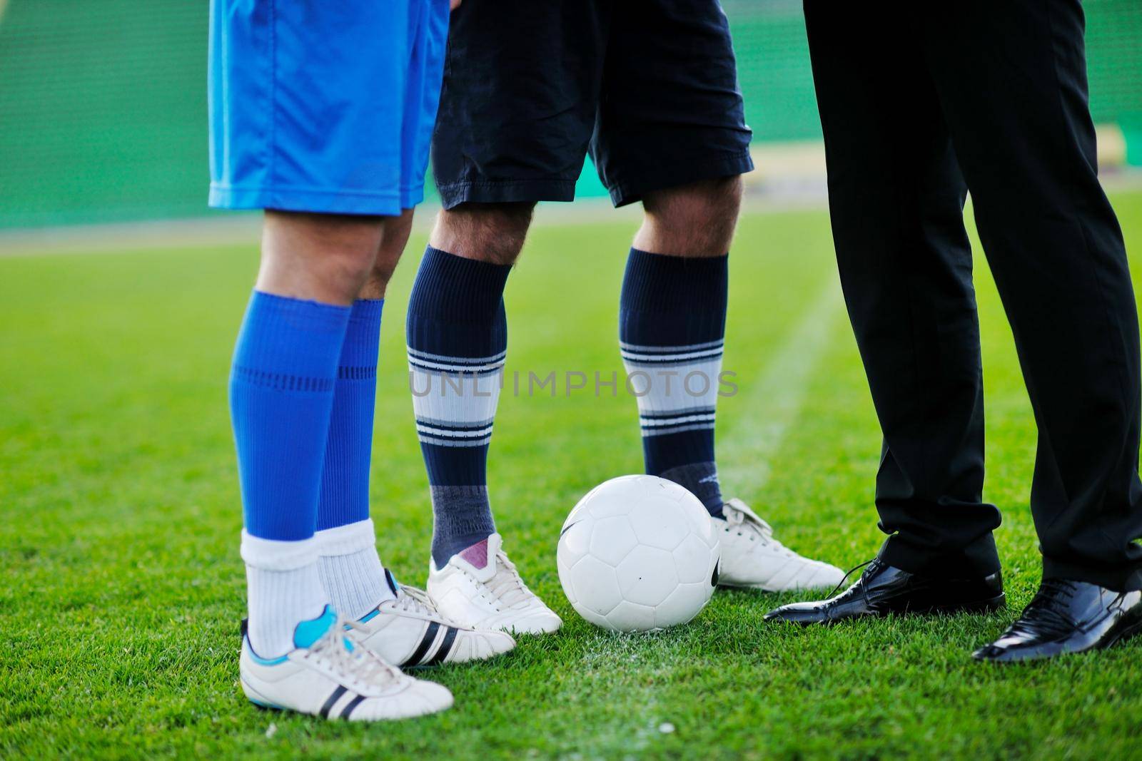 soccer  sport manager in business suit coach and football player on stadium with green grass and white ball