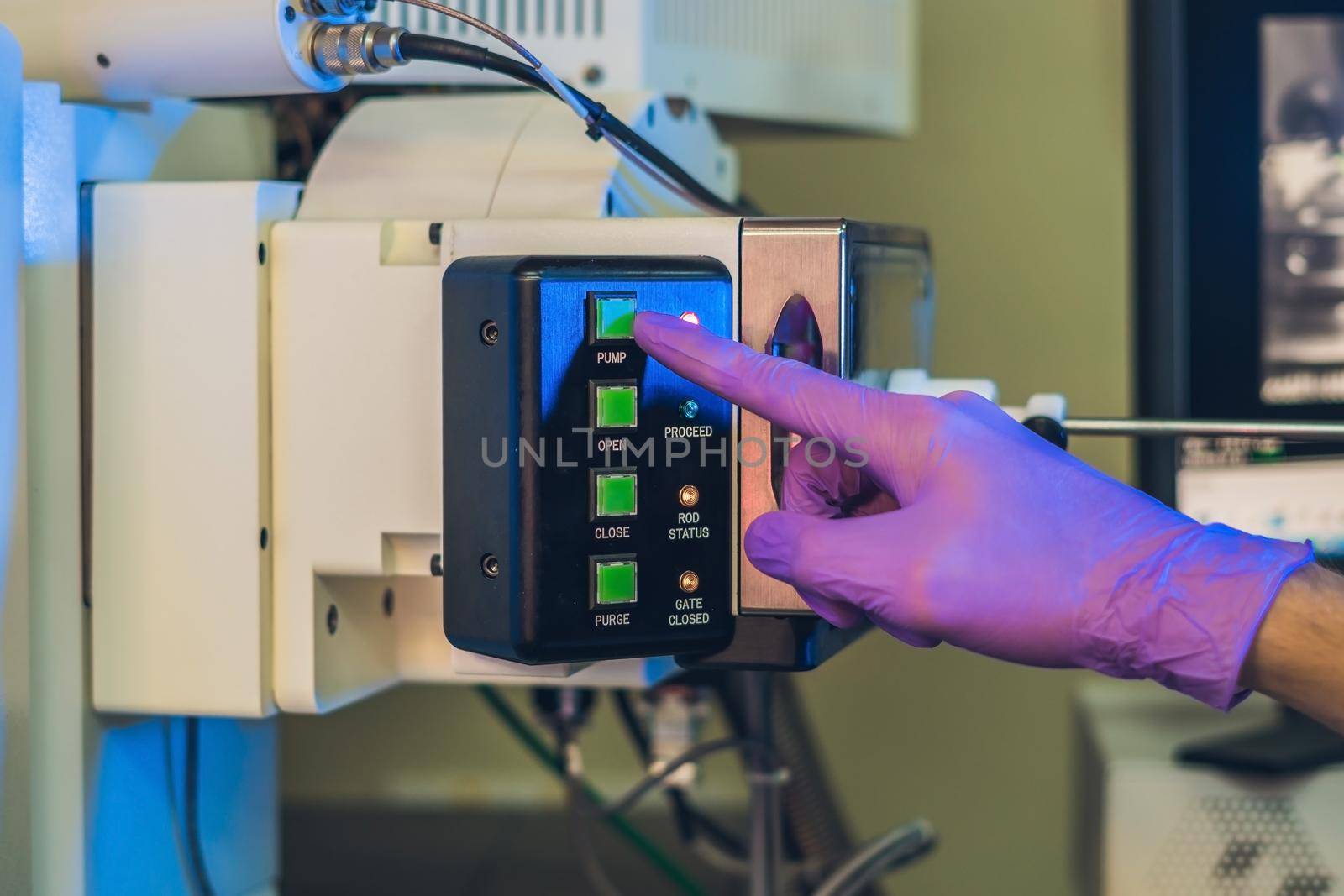 Scientist in a laboratory works with an electron microscope gateway. Putting a sample into a microscope chamber.